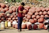 A  man checks earthern pots sold by a wayside vendor 